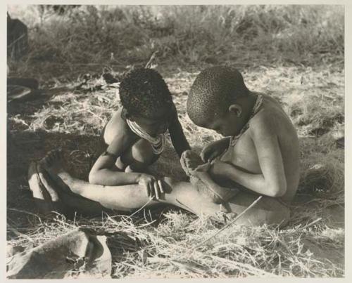 Di!ai's son /Gaishay and !U's son /Gaishay playing with a shoe
