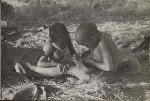 Di!ai's son /Gaishay and !U's son /Gaishay playing with a shoe
