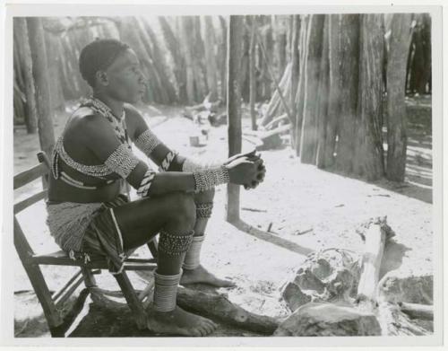 Makiena (Muremi's wife) sitting in her kraal, wearing her Kwangali beads and copper anklets (print is a cropped image)