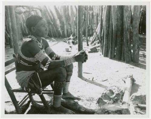 Makiena (Muremi's wife) sitting in her kraal, wearing her Kwangali beads and copper anklets (print is a cropped image)