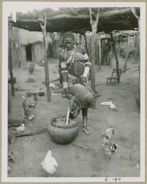 Makiena pouring milk from a calabash into a bowl (print is a cropped image)