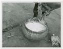 Makiena pouring milk from a calabash into a bowl; close-up of the bowl (print is a cropped image)