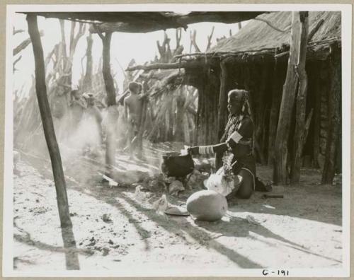 Rungiero preparing squash for cooking, and a group of children beside the outside kraal fence (print is a cropped image)