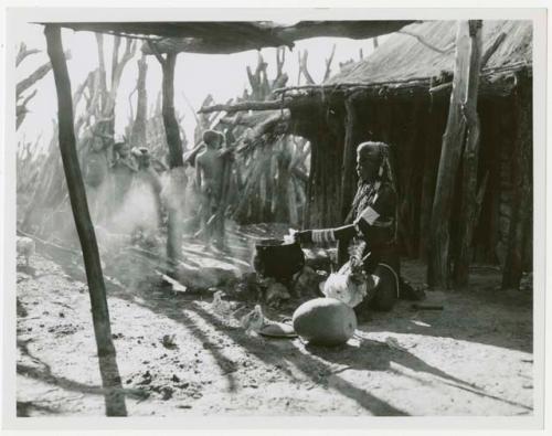 Rungiero preparing squash for cooking, and a group of children beside the outside kraal fence (print is cropped image)