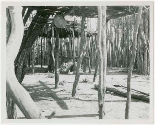 Inside Muremi's kraal; shows the outside fence, the roofs for shade, and a churn (print is a cropped image)