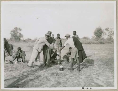 Group from the WNLA (Witwatersrand Native Labor Association) convoy eating (print is a cropped image)