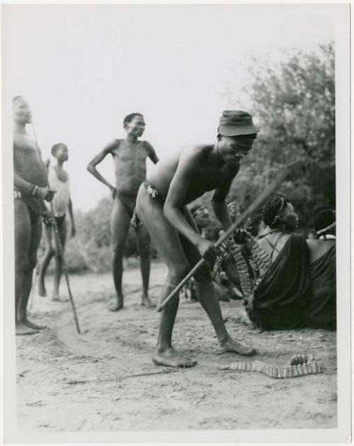 Man putting on dance rattles (print is a cropped image)