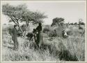 John Marshall squatting, Dabe and another expedition member standing with camera (print is a cropped image)