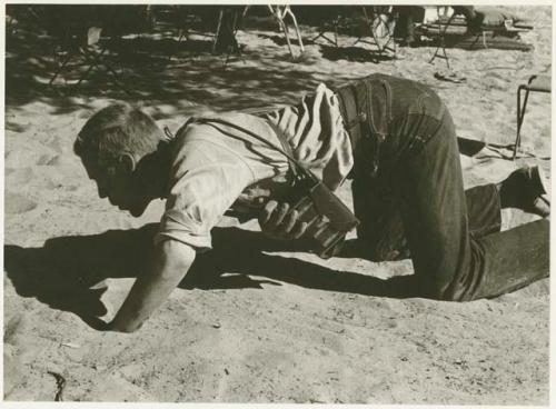 John Marshall kneeling in the sand (print is a cropped image)