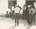 Group of people, including Daniel Blitz and John Marshall, gathered around in front of store at Sehitwe
