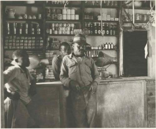 Interior of a trader's store at Sehitwe, with three men standing













