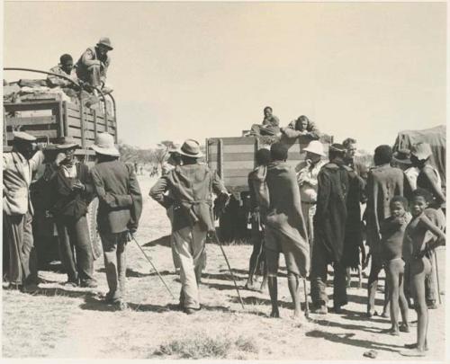 People standing next to expedition members near trucks


