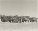 People standing next to expedition members near trucks




