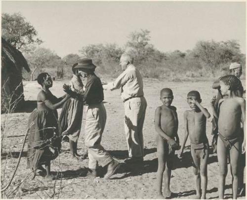 Lorna Marshall and //Kushay greeting each other; with Laurence Marshall and !Ungka behind them



