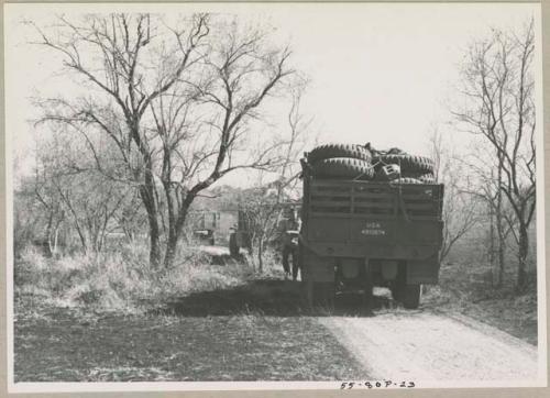 Man standing next to an expedition truck stopped in the track

