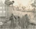 Boy, possibly "Little ≠Gao," handing something to an unidentified Ju/'hoan man in a Dodge truck


















