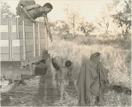 Boy, possibly "Little ≠Gao," handing something to an unidentified Ju/'hoan man in a Dodge truck


















