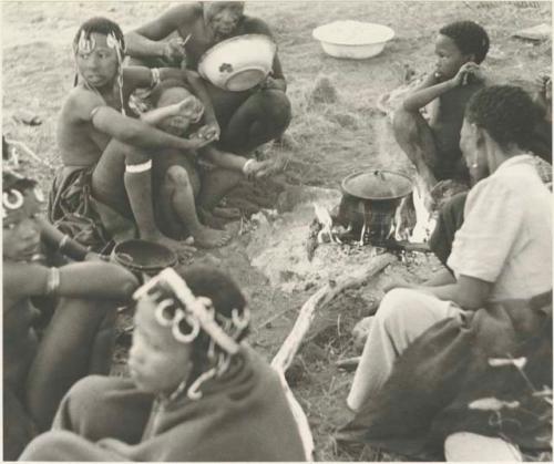 //Kushay, "Little ≠Gao", !Ungka, "Old Gau", and other unidentified people seated around a pot on a fire





















