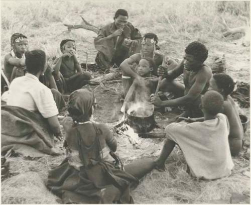 //Kushay, "Little ≠Gao", !Ungka, and other unidentified people seated around a pot on a fire while "Old Gau" stirs the pot






















