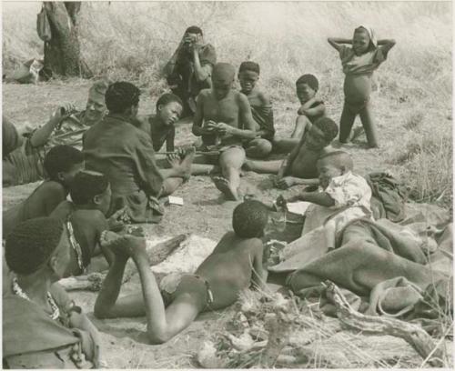 "/Qui Hunter" putting on clothes clothes given to him by the Marshalls  while unidentified people watch











































