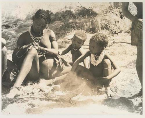 /Naoka and Di!ai and her two sons, Debe and /Gaishay, all seated