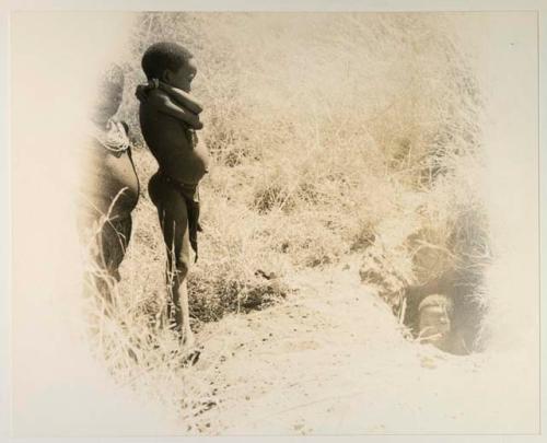 Two Ju/'hoan boys, standing, and one boy, likely "Little ≠Gao", in a pit (damaged negative)
