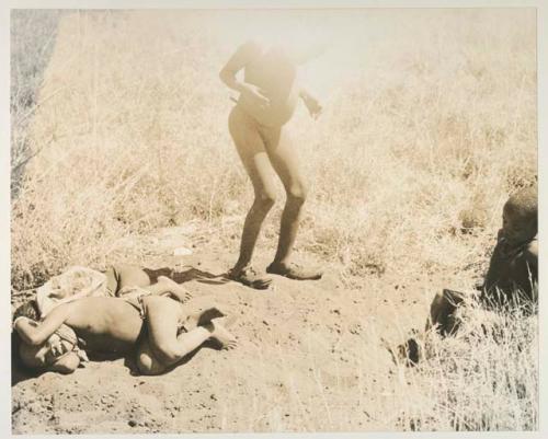 Four unidentified boys, two lying on the ground, and Elizabeth Marshall Thomas
