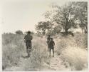 Elizabeth Marshall Thomas walking with three unidentified boys
