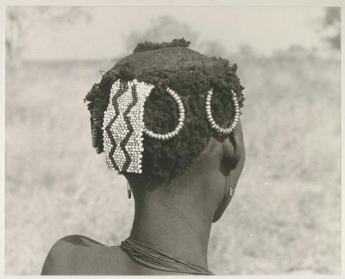 Back of /Goishay's (wife of ≠Gao and daughter of Khwo//o) head with ornaments and safety-pin earrings