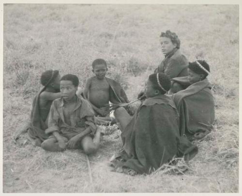 Elizabeth Marshall Thomas and children sitting around the fire
