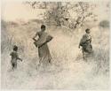 Two women and a child walking in the grass


