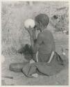 "Old Xama" holding an ostrich egg to her eye to see how clean it is inside





















