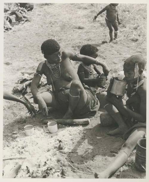 !U, !Ungka Norna, and an unidentified, visiting girl all seated and holding cans, and Debe in the background


























