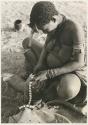 Woman trimming the edge of a leather headband with a knife


























