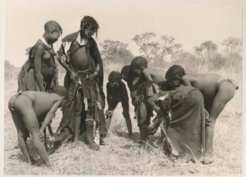 Ju/'hoan youth crowded around a girl wearing a laced boot

























