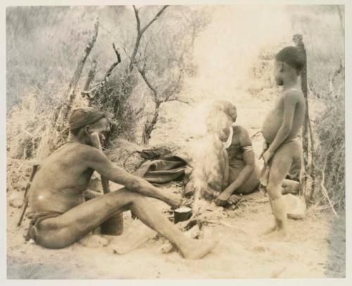 Three-member family in their living place, with the smoke of the fire rising
























