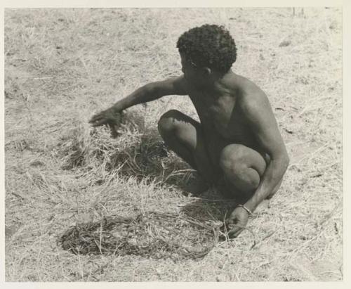 ≠Toma holding a carrying net with one hand and grabbing the grass with the other
























