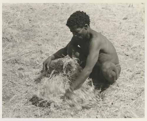 ≠Toma with a carrying net, squatting on the grass

























