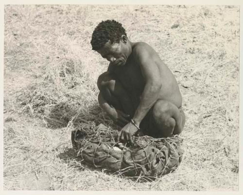 ≠Toma lining a carrying net with a small kaross to pack it with rattles, ostrich eggshells, etc.

























