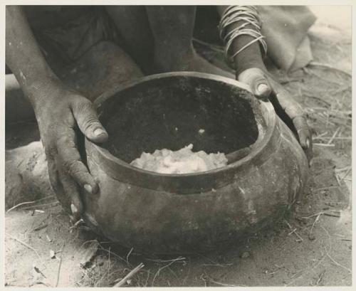 Wooden bowl with food held by a person's hands
























