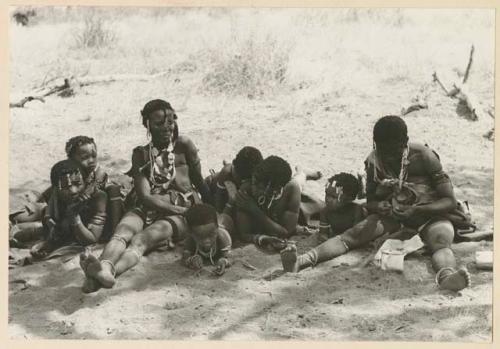 Group of women and children lying and sitting on the ground, including /Goishay (wife of ≠Gao) on extreme left

























