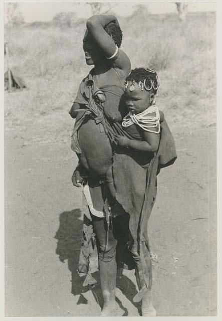 Woman with a child tied in her kaross, showing modesty apron of leather with a beaded border

























