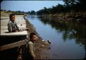 Two boys near dock along canal