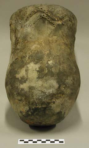 Ceramic complete vessel, raised pattern with punctates on flared neck, flattened