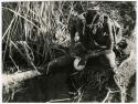 "Waterhole / Gwia": Woman filling an ostrich eggshell with water at a waterhole (print is a cropped image)