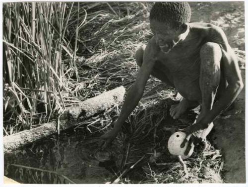 "Waterhole / Gwia": "Old /Gaishay" of Band 4 filling his ostrich eggshell with water (print is a cropped image)