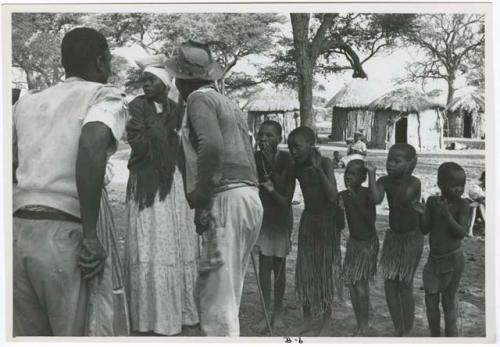 [No folder title]: Judas Kangengi and Ananias singing in front of a line of women and boys clapping (print is a cropped image)