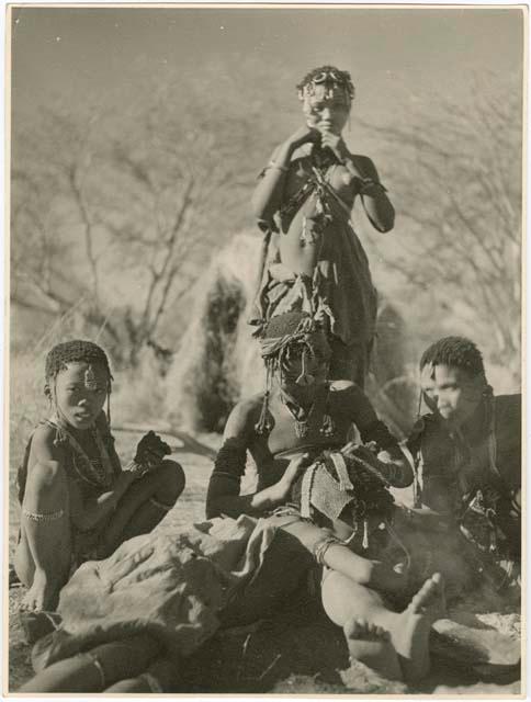 "Grooming & haircuts": Girls and women sitting, one delousing another (print is a cropped image)