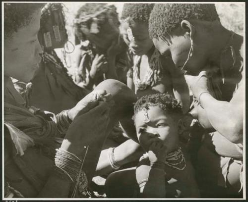 "Reel 224, 18-36, Ex III / b/w prints made from color slides, huddle": Group of women and children sitting closely together (print is a cropped image)