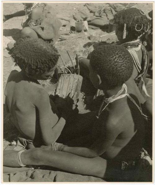 "Music": Children sitting, one playing a //guashi (print is a cropped image)